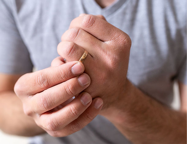 man who can't make a fist rubs his sore hand