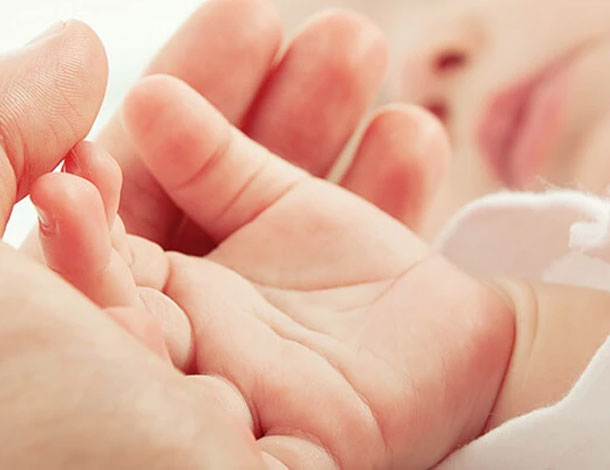 baby holding mothers hand