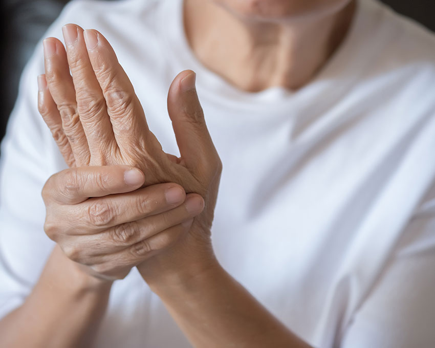 elderly woman rubbing hand