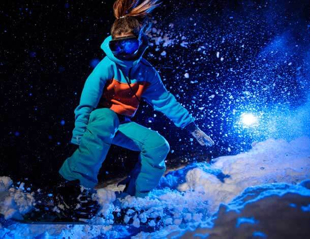 Snowboarder skiing down mountain.